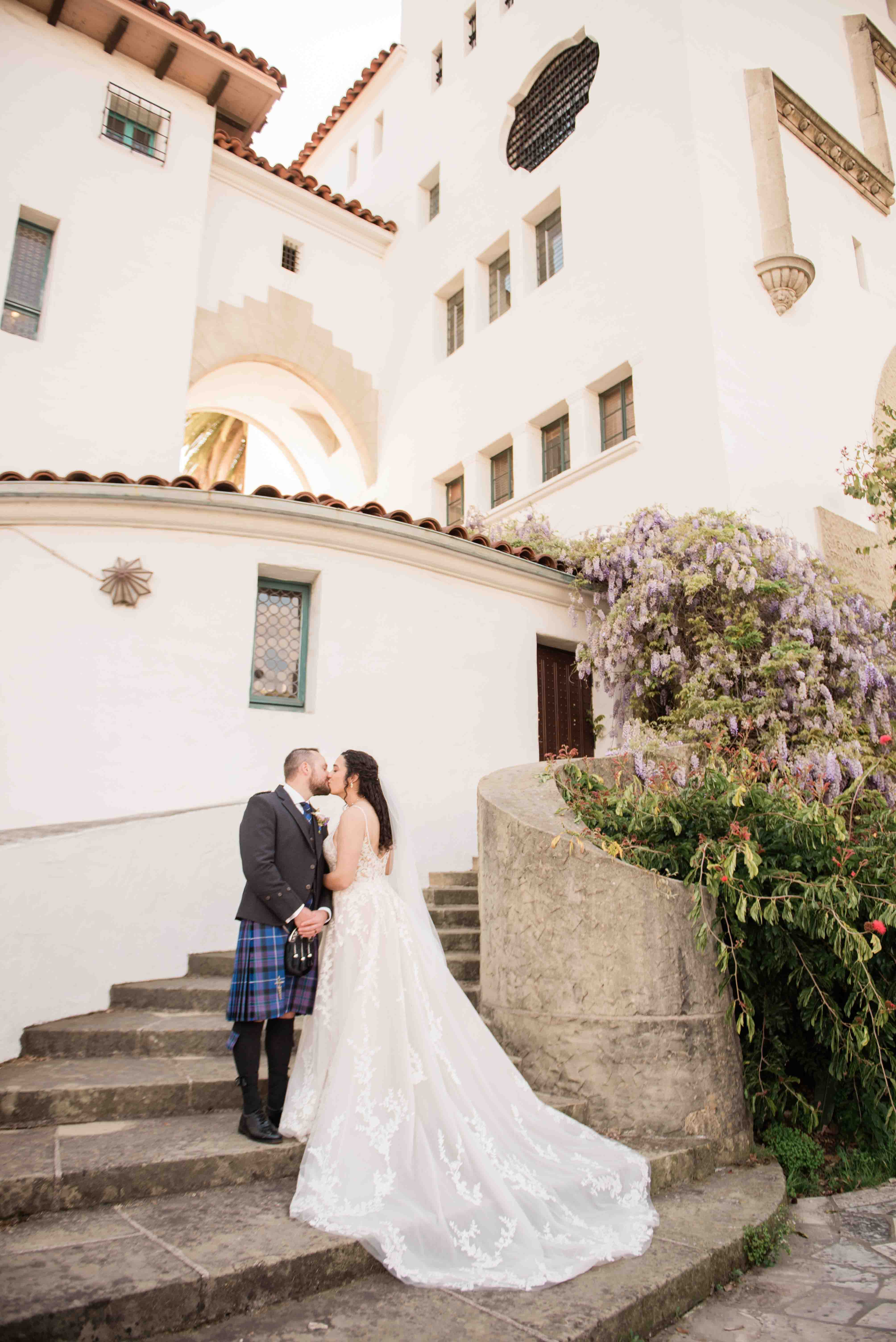 bride and groom kissing on stairs at santa barbara courthouse